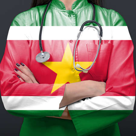 Doctor representing healthcare system with National flag of Surinameの写真素材
