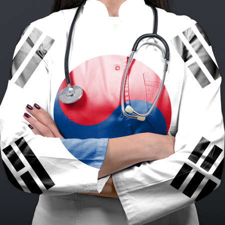 Doctor representing healthcare system with National flag of South Koreaの写真素材