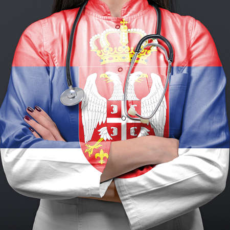 Doctor representing healthcare system with National flag of Serbiaの写真素材