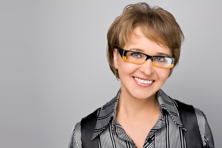 Portrait of the business woman in glasses on a grey backgroundの写真素材