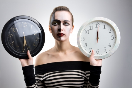 Portrait of a cute girl with black and white clocks on grayの写真素材