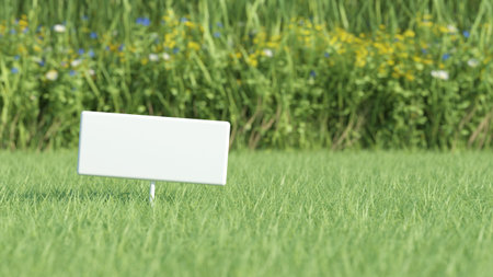 Blank white board on green grass field の写真素材
