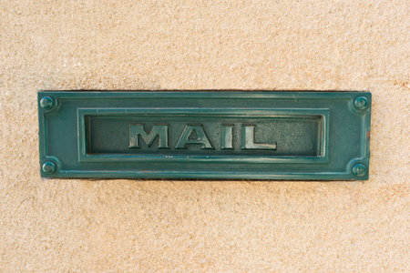 Green metal mailbox on yellow wallの写真素材