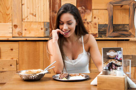Young woman eating in restaurantの写真素材