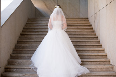 Attractive charming bride in a white dress standing on the ladder
