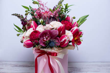 beautiful floral arrangement in a hat box, shabby white wooden tableの写真素材