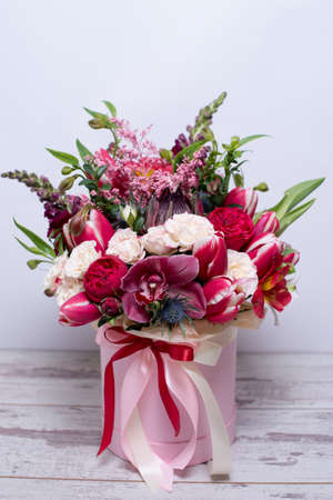 beautiful floral arrangement in a hat box, shabby white wooden tableの写真素材