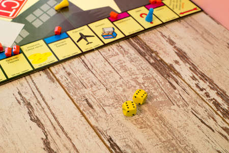two dices on the background of colorful blurred fantasy Board games, on wood tableの写真素材