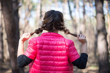 Cute girl teenager with two pigtails hair back viewの写真素材