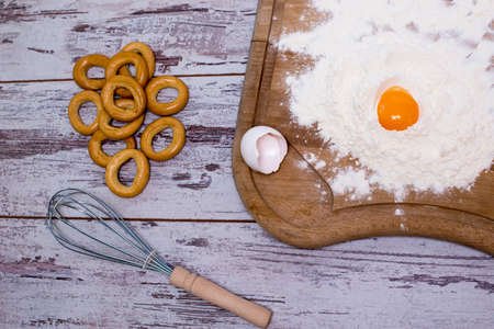 Baking concept. Sprinkled flour and eggs on wooden cutting board, cooking ingredients. Prepare for making yeast dough. Top view, copy spaceの写真素材