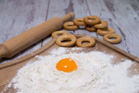 Baking concept. Sprinkled flour and eggs on wooden cutting board, cooking ingredients. Prepare for making yeast dough. Top view, copy spaceの写真素材