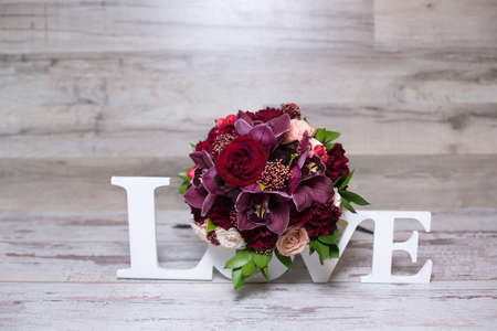 beautiful flower arrangement with the inscription LOVE on the shabby wooden table with space for textの写真素材