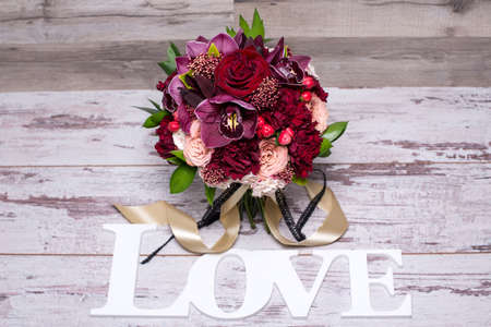 beautiful flower arrangement with the inscription LOVE on the shabby wooden table with space for textの写真素材