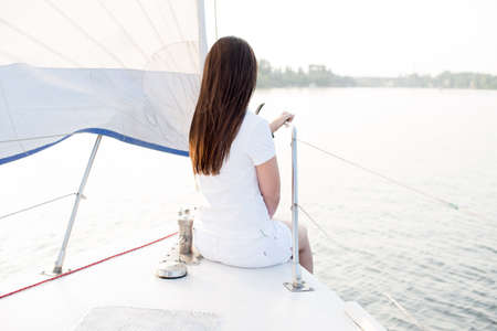 wind in hair yachting girl yachting on sailboat. Back view.の写真素材