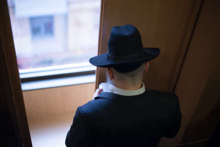 Jew Hasid ethnic headdress. The Jew prays before the window. view from aboveの写真素材
