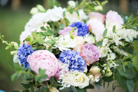 wedding bouquet of purple flowers and greenery on the background of green grassの写真素材