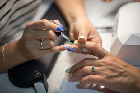 Manicure. Master make nail paint. hands closeupの写真素材