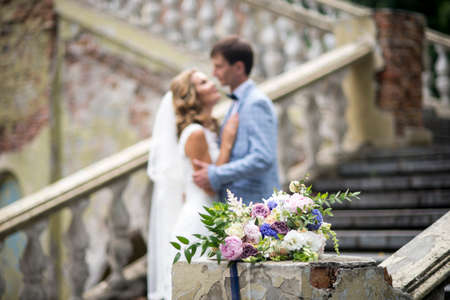 Wedding bouquet in focus and couple in the background.の写真素材