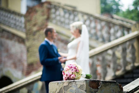 Wedding bouquet in focus and couple in the background.の写真素材