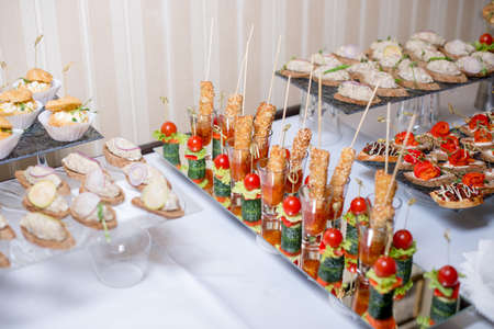 Buffet table of reception with burgers, cold snacks, meat and salads.の写真素材