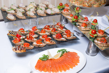 Buffet table of reception with burgers, cold snacks, meat and salads.