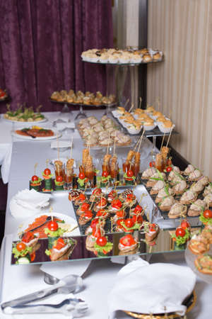 Buffet table of reception with burgers, cold snacks, meat and salads.の写真素材