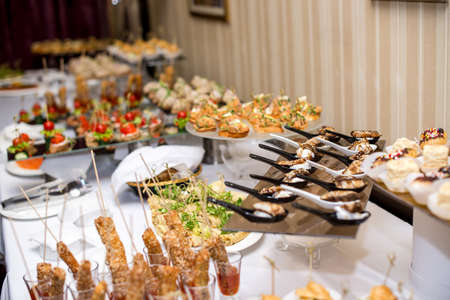 Buffet table of reception with burgers, cold snacks, meat and salads.の写真素材