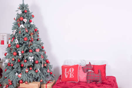 Beautiful holiday decorated room with Christmas tree with presents under it. bed with pillowsの写真素材
