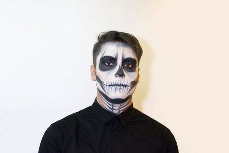 man in make-up Halloween. drawing a vampire, skeleton on his face. Close-up photo.の写真素材