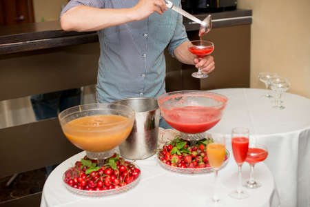 cocktail in a glass of champagne, punch and fruit in the backgroundの写真素材