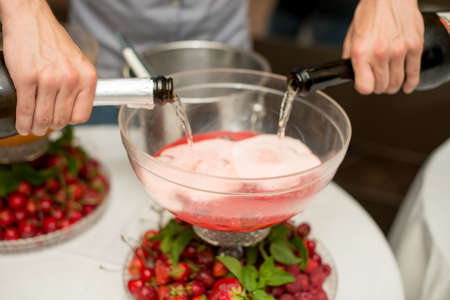 Beverage with ice cubes. Pouring champagne. mint and fruit are out of focusの写真素材