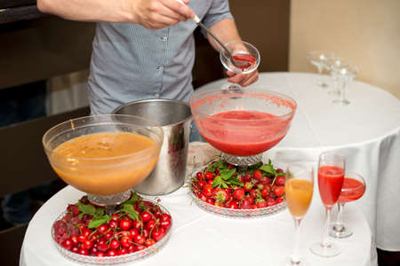 cocktail in a glass of champagne, punch and fruit in the background.の写真素材