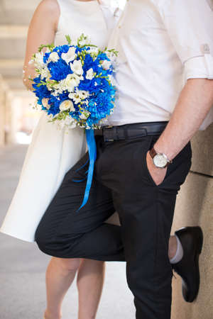 Bride and groom holding bridal bouquet of blue chrysanthemum, freesia, eustoma and peony. close up.の写真素材