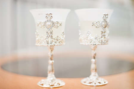 two glasses of champagne with a golden ribbon on a mirror with a spot light background.の写真素材