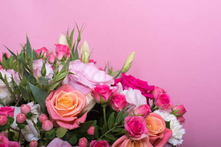 beautiful floral arrangement in the box, pink and yellow rose, pink eustoma, green and pink chrysanthemum, white carnation, pink dahlia on pink background with space for text.の写真素材