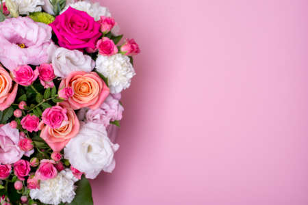 beautiful floral arrangement in the box, pink and yellow rose, pink eustoma, green and pink chrysanthemum, white carnation, pink dahlia on pink background with space for text.の写真素材