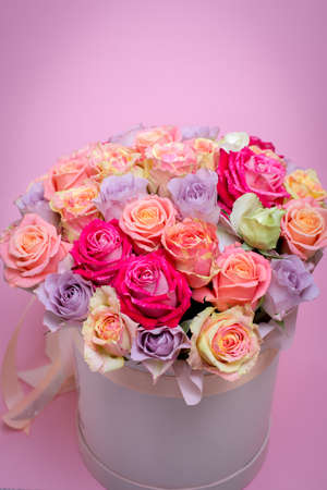 Beautiful bouquet of roses in a gift box. Bouquet of pink roses. Pink roses close-up. on pink background, with space for textの写真素材