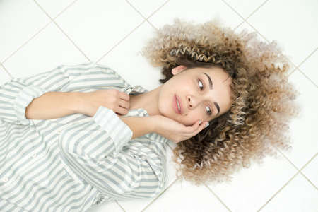 Blondegirl with curly hair . Beautiful model woman with wavy hairstyleの写真素材