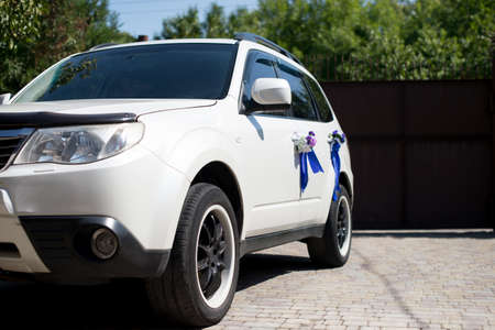 white car decorated for a wedding. greens in the backgroundの写真素材