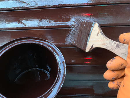 man paints a metallic profile with brown paint.の写真素材