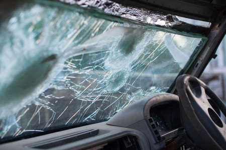 Bullet hole on a car windshield. Car window after a raid has a bullet hole. Broken glass. Bullet holes in a front windshield. Broken Windshield.の写真素材