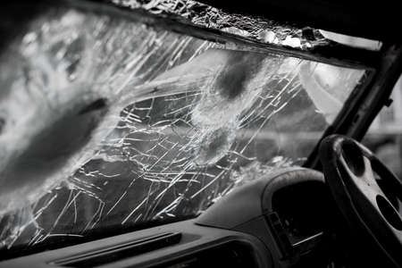 Bullet hole on a car windshield. Car window after a raid has a bullet hole. Broken glass. Bullet holes in a front windshield. Broken Windshield.の写真素材