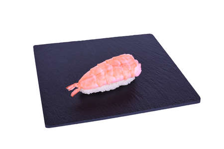 Traditional fresh japanese sushi on black stone Nigiri ebi on a white background. Gunkan ingredients: tiger shrimp, philadelphia cheese, riceの写真素材