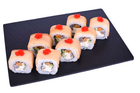 Traditional fresh japanese sushi rolls on a black stone Mikado on a white background. Roll ingredients: mussels, escolar fish, izumi perch fish, philadelphia cheese, red tobiko, nori, riceの写真素材