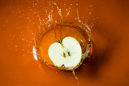 sliced apple splashing on juiceの写真素材