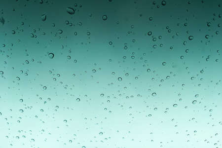 rain drops texture on window glass toned wallpaper horizontal viewの写真素材