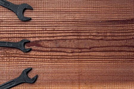 black steel wrench different sizes tool set layout on dark brown wood textured background with copy spaceの写真素材