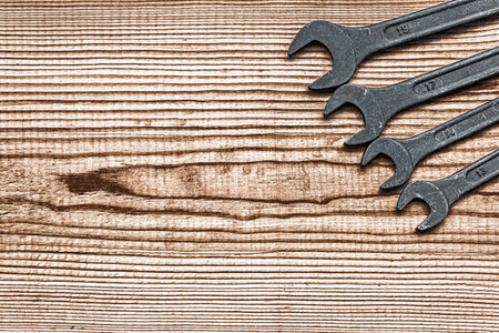 black steel wrench different sizes tool set layout on dark brown wood textured background with copy spaceの写真素材