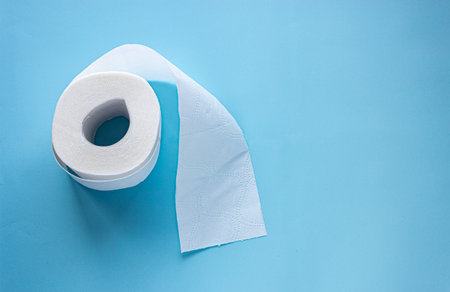 roll of white toilet paper on blue background layout. copy space text. banner hygiene supplies conceptの写真素材