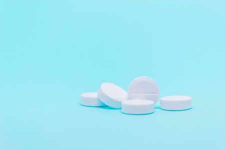 white a round pills on a blue background close-up medical treatment copy space conceptの写真素材